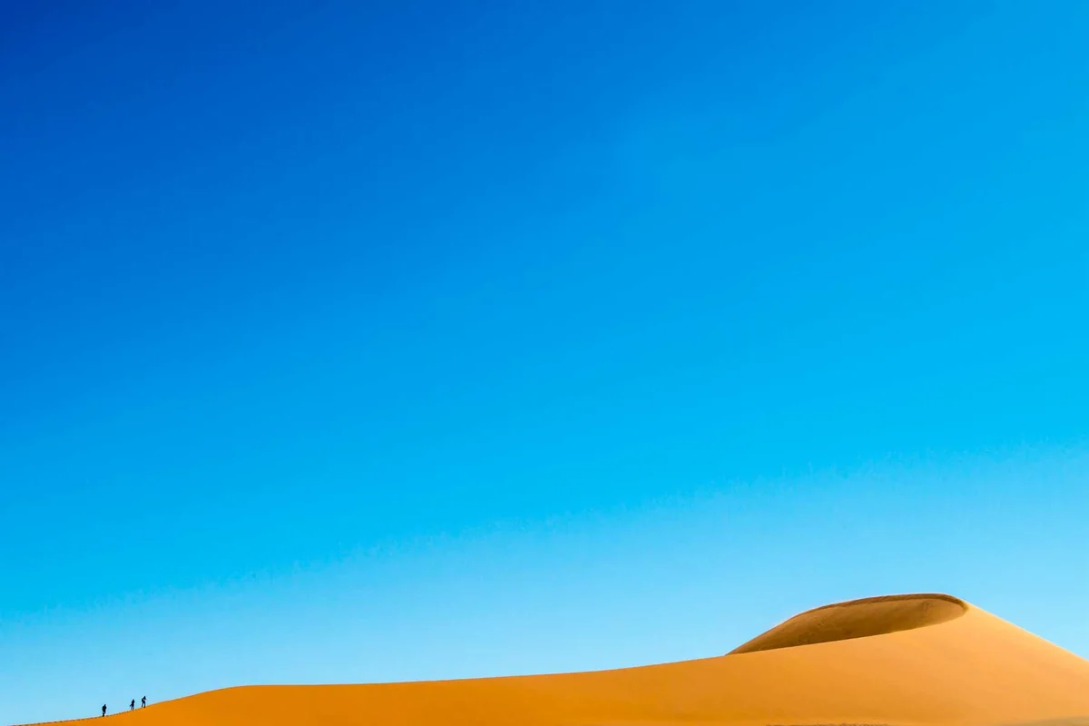 Due figure nel deserto della Namibia con ampio spazio negativo — pocket visivo nella fotografia di paesaggio