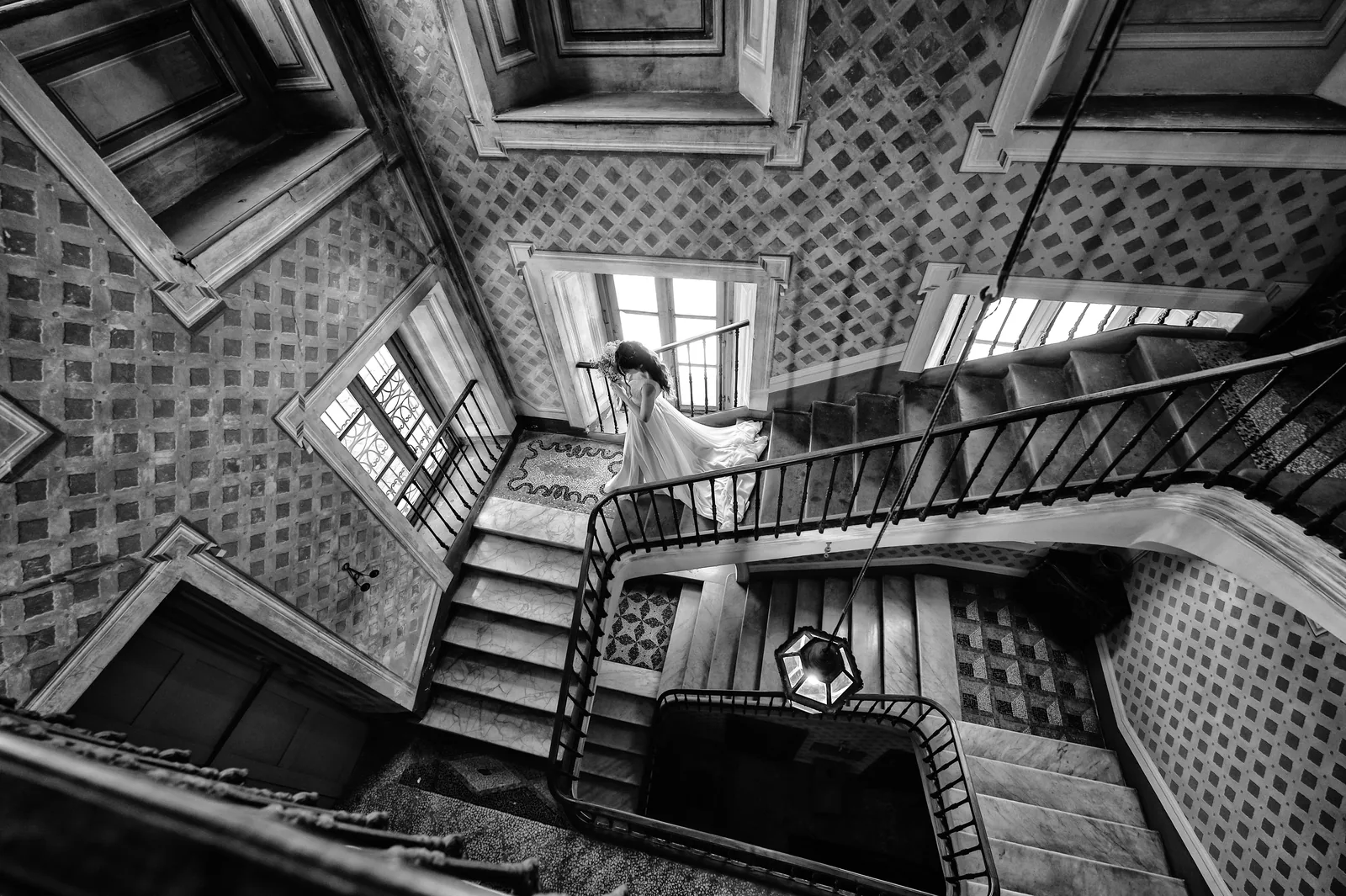 A spiral staircase seen from above with the bride at the window, La Scrivana, black and white