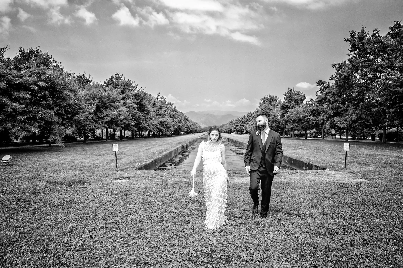 The couple walking along the canal of the gardens, Reggia di Venaria, black and white