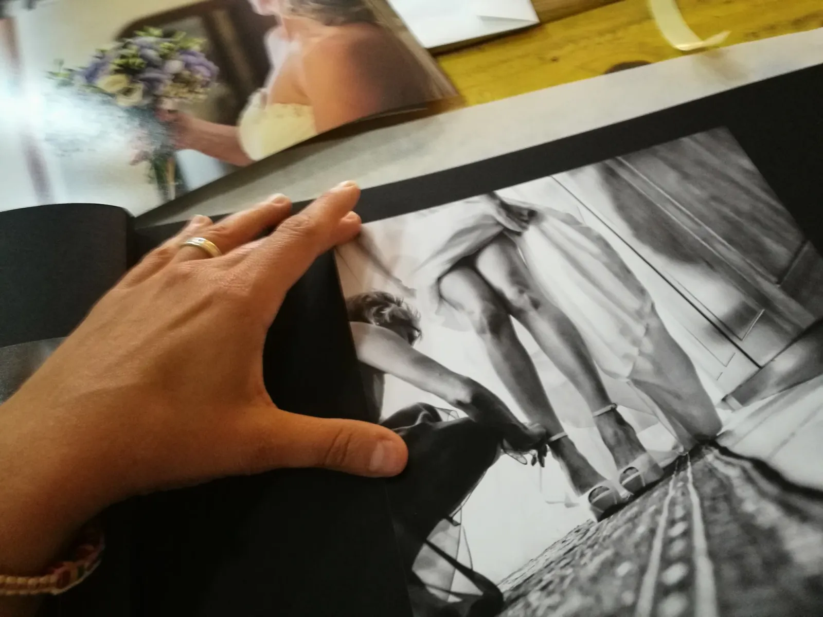 Le mani di Elisabetta Rosso sfogliano un album di matrimonio artigianale con stampe fine art