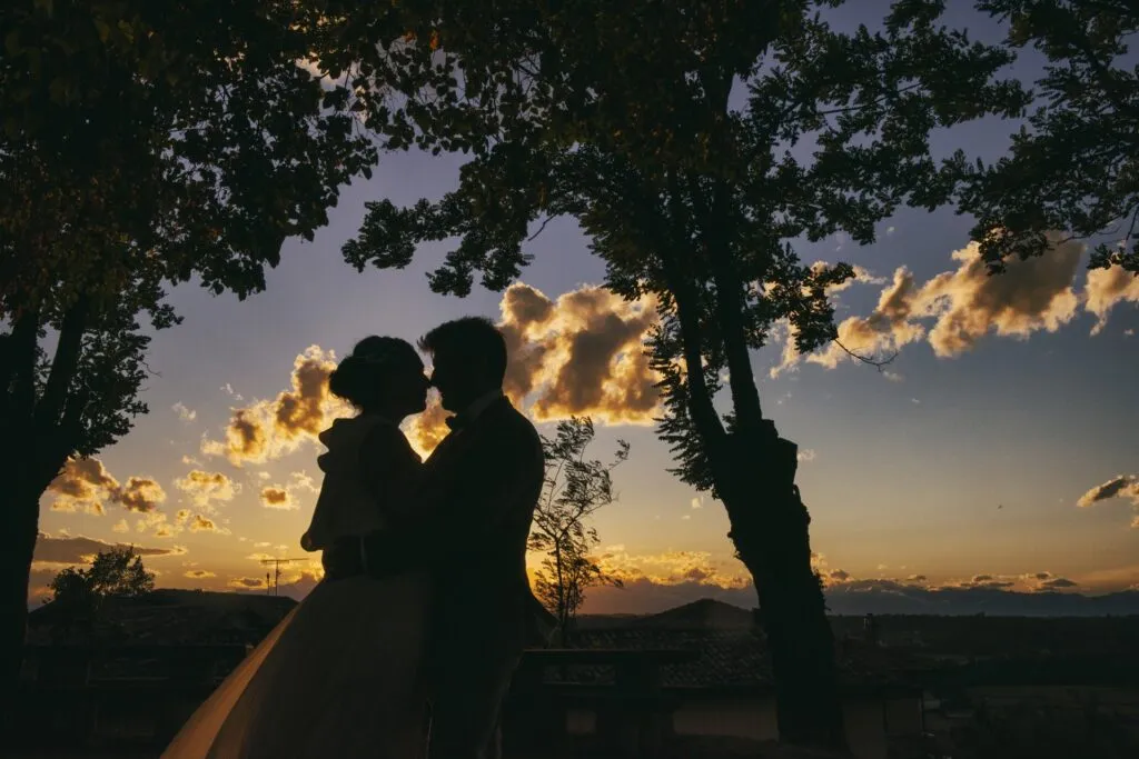 Ritratto degli sposi in silhouette al tramonto sulle colline delle Langhe