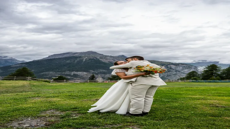 Bacio degli sposi con il paesaggio alpino di Bardonecchia