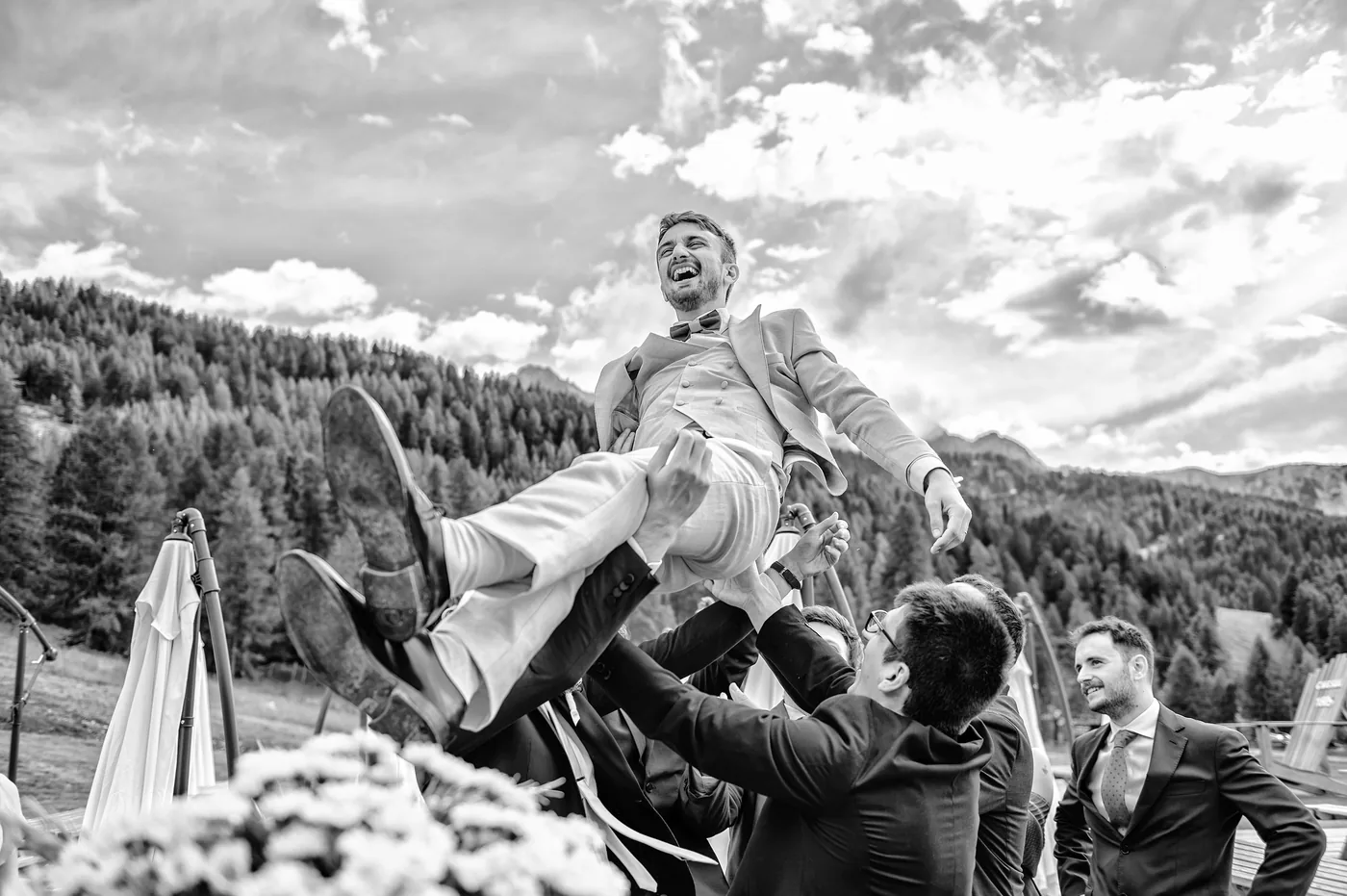Lancio dello sposo tra gli amici in bianco e nero, matrimonio Chesal Bardonecchia