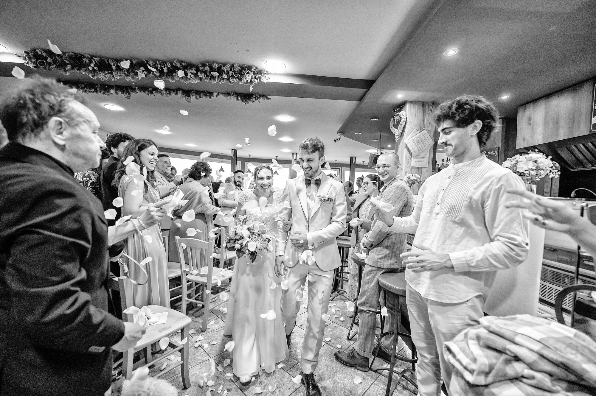 Uscita degli sposi tra gli invitati in bianco e nero, matrimonio Chesal Bardonecchia
