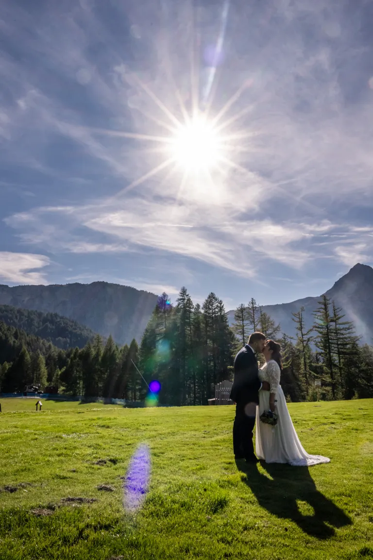 Sposo con sole alto e vetta delle Alpi Cozie