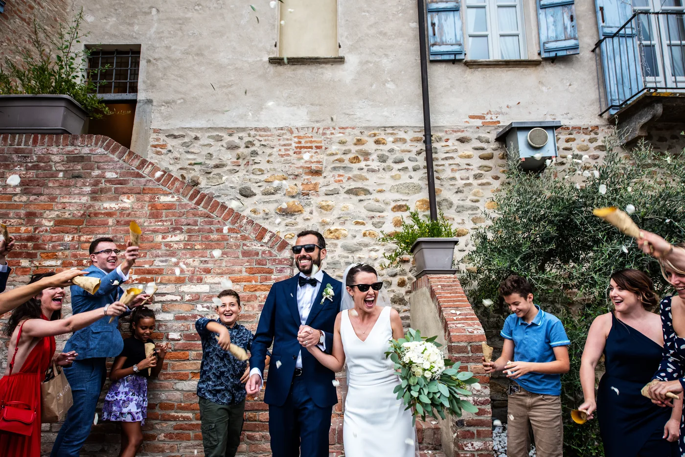 Uscita degli sposi tra gli invitati a fine festa, matrimonio Castello di Grinzane Cavour Langhe
