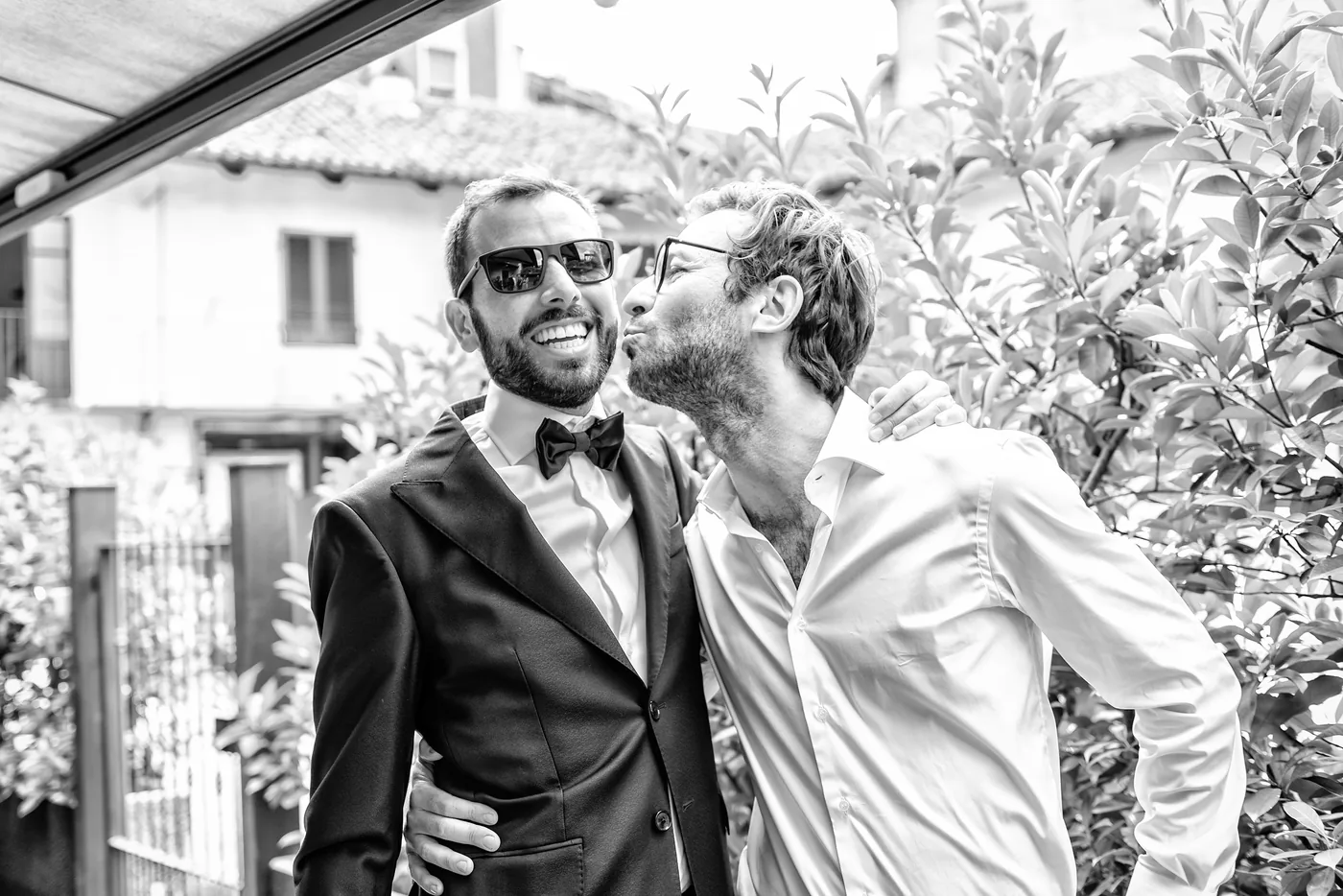 Sposo abbraccia gli amici in bianco e nero, matrimonio Castello di Grinzane Cavour Langhe