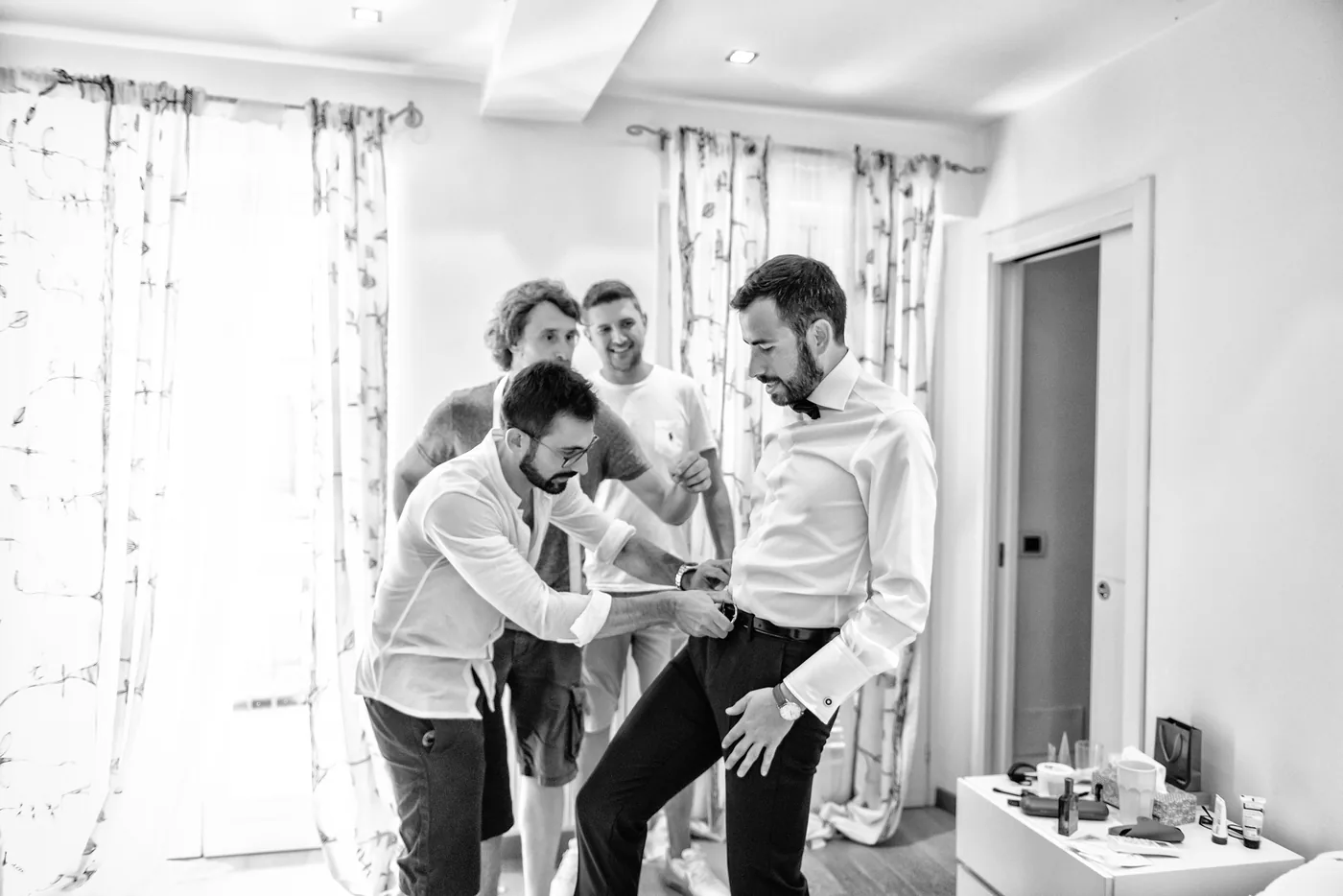 Sposo e amici alla finestra in bianco e nero, matrimonio Castello di Grinzane Cavour Langhe