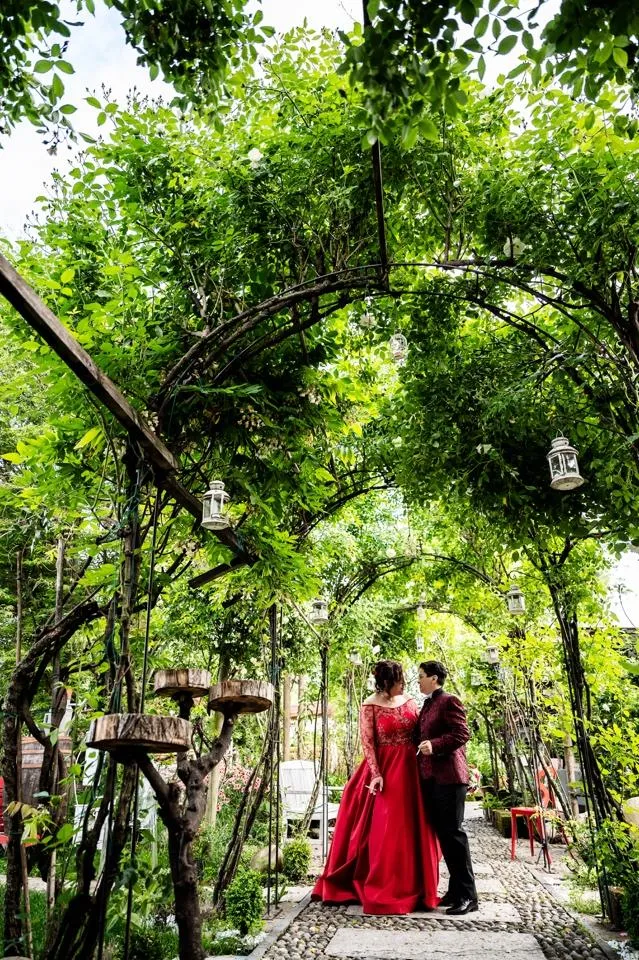 Le due spose sotto il pergolato di glicine nel giardino de La Vià