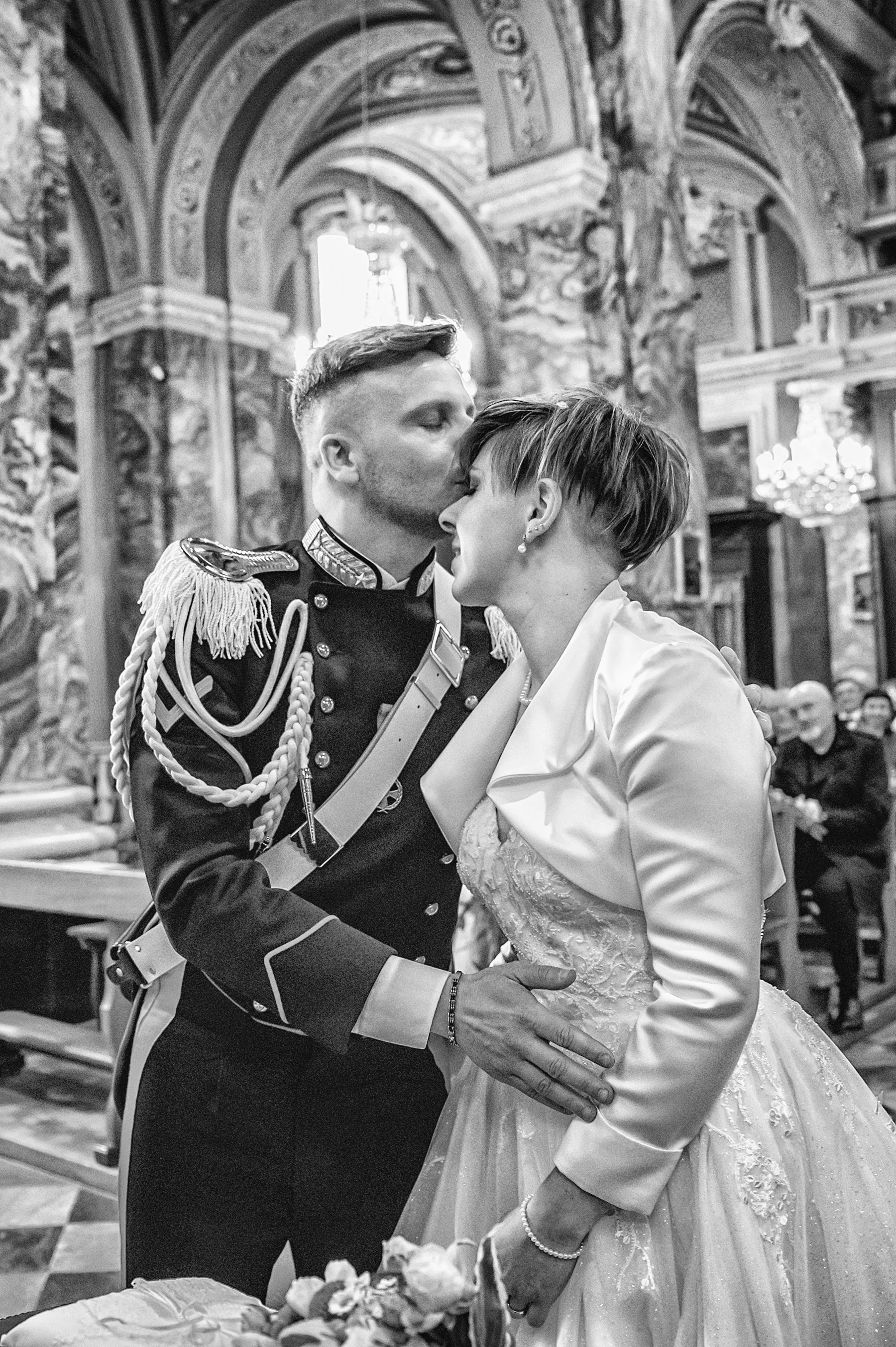 Bacio degli sposi durante la cerimonia, lo sposo in uniforme, Pinerolo, fotografia in bianco e nero