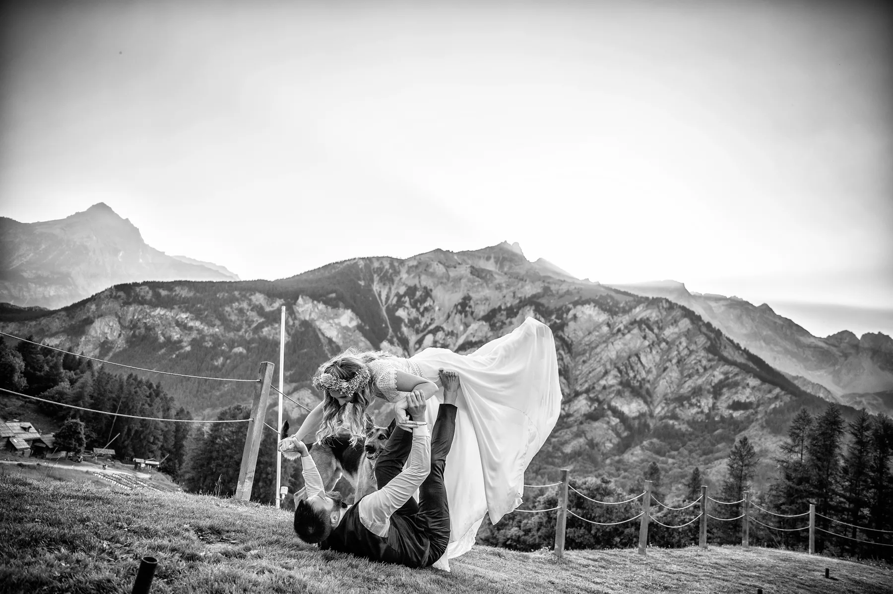 Gli sposi sollevati dagli amici tra le montagne, Bardonecchia, fotografia in bianco e nero