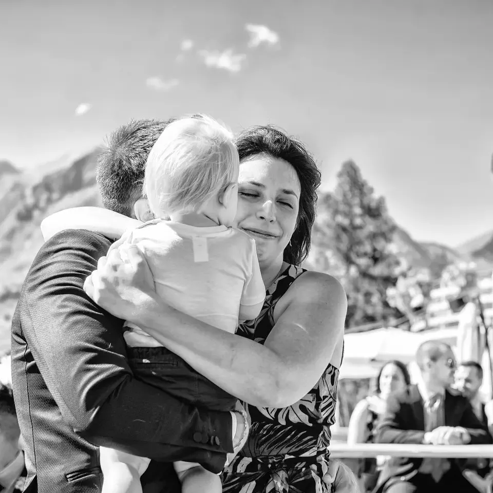 Sposo abbraccia il figlio durante la cerimonia in montagna