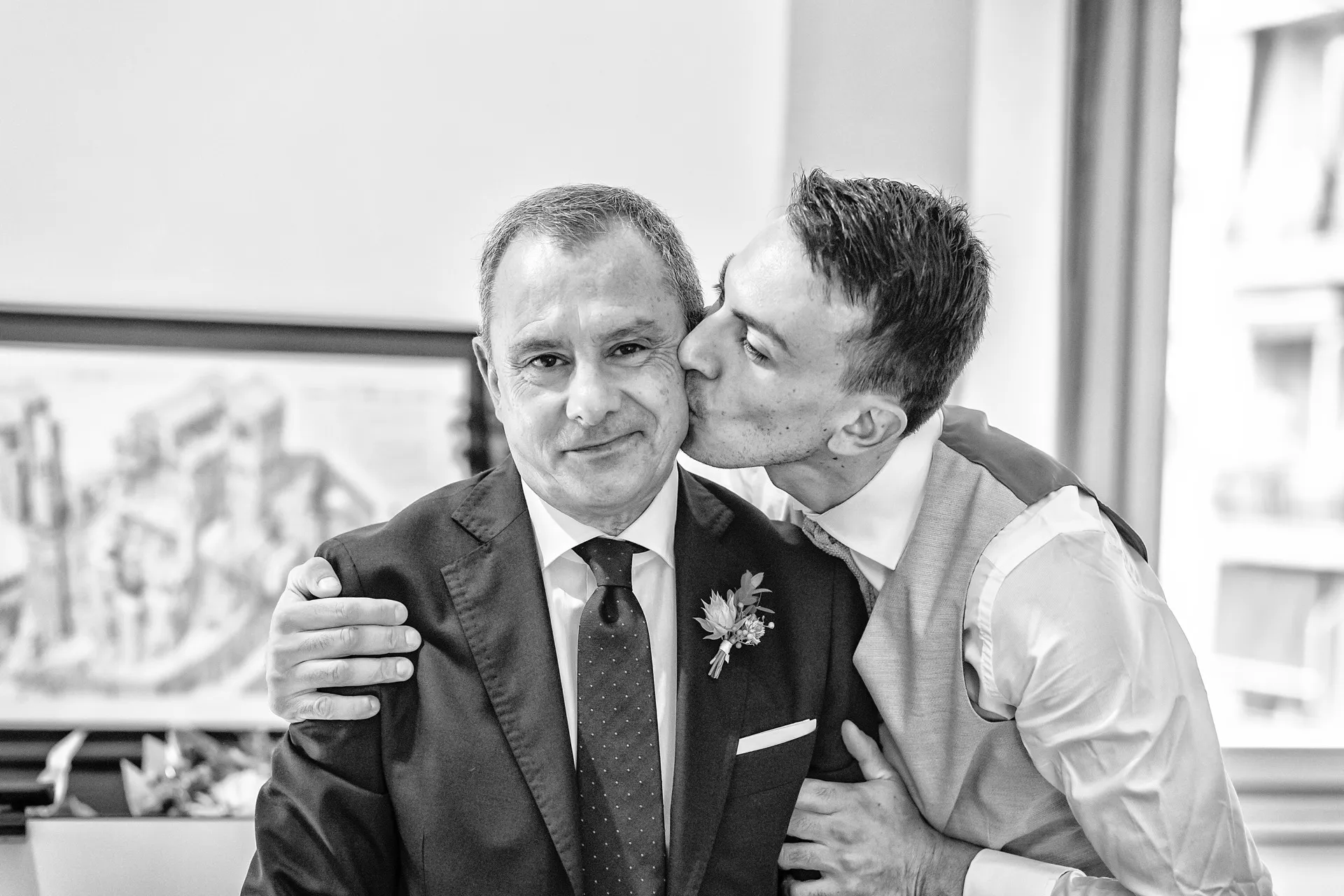 Lo sposo bacia il padre, momento di commozione durante i preparativi, fotografia in bianco e nero